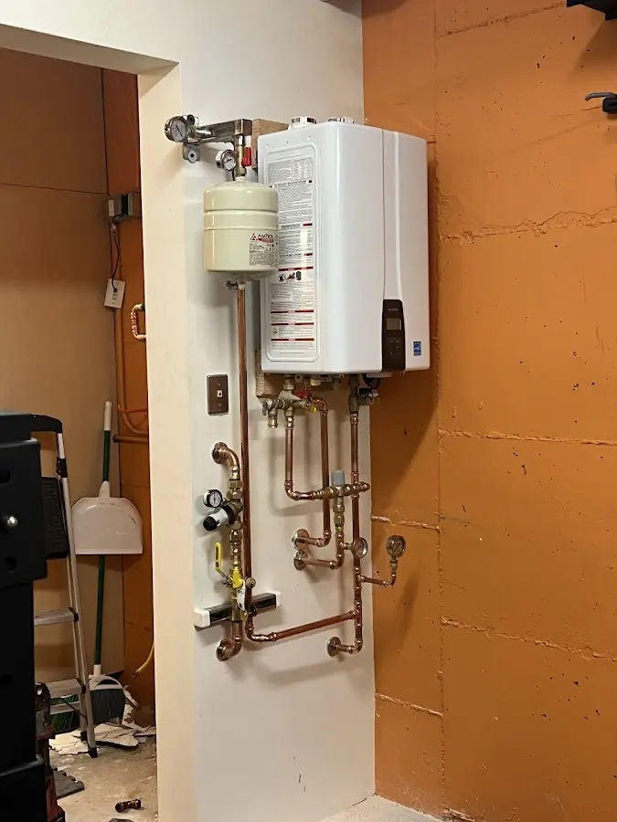 Plumbing technician inspecting water heater connections in Waldwick